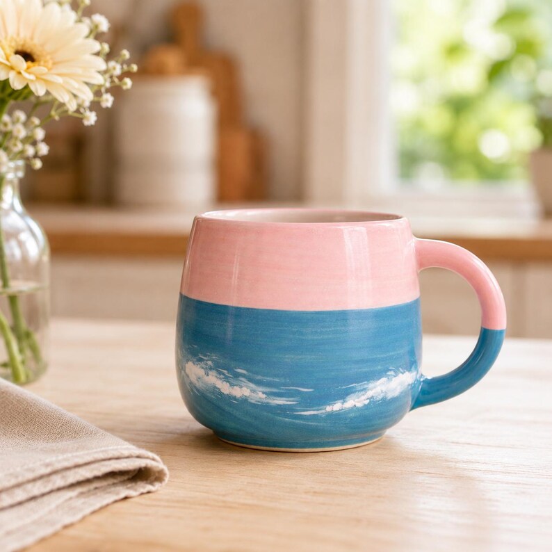 Keramik-Katzentasse (ca. 325 ml) – Kaffeebecher in Rosa und Blau mit Strand-Sonnenuntergang, orangefarbener Katze und Segelbooten